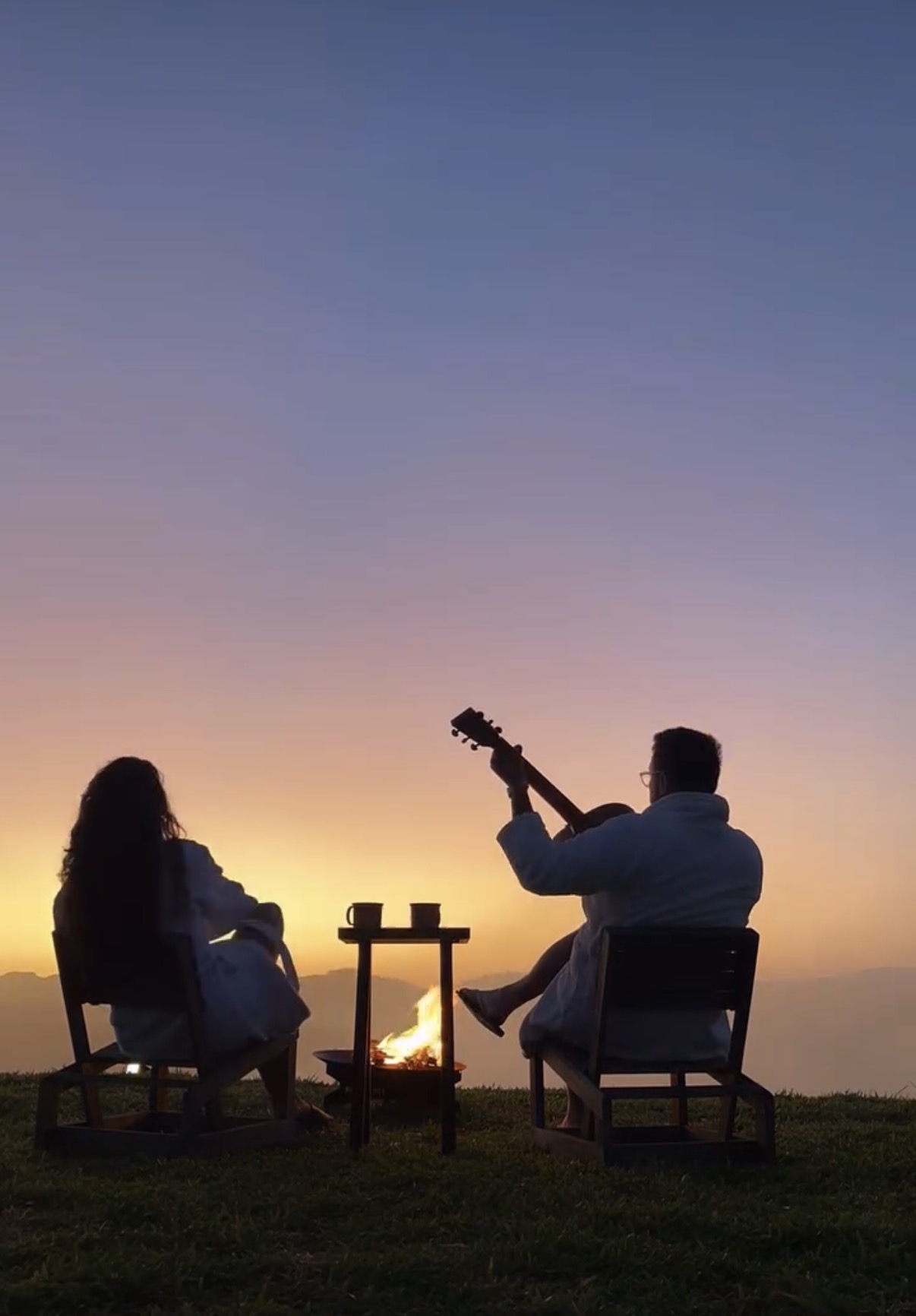 Casal ao pôr do sol com violão